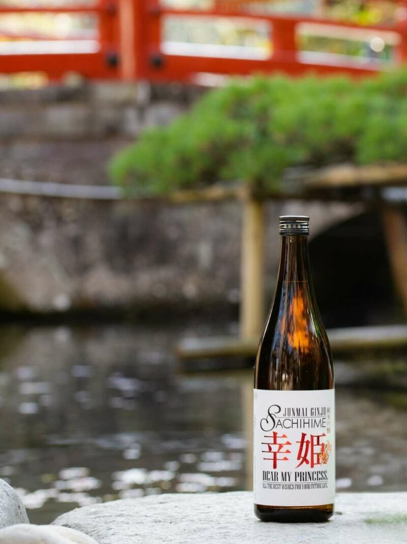Sake Junmai Ginjo Sachihime Dear My Princess from Sachihime Brewery. The bottle is in a Japanese garden.