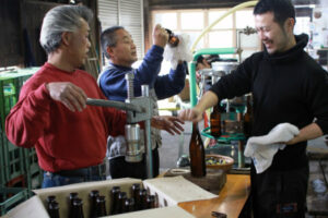 des personnes avec une bouteille de saké et des machines